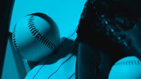 Nahaufnahme-Eines-Studio-Baseball-Stilllebens-Mit-Ballfängerhandschuh-Und-Mannschaftstrikot-Mit-Blauer-Beleuchtung-1